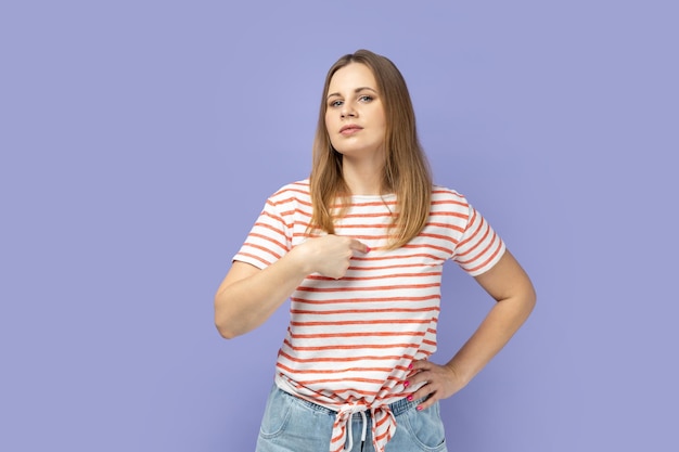 Mulher apontando orgulhosamente para si mesma, gabando-se de sucesso, sentindo-se arrogante e autoconfiante