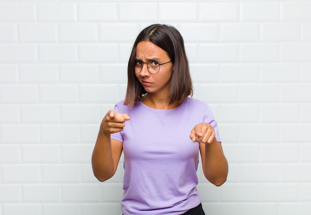 Mulher apontando para a frente com os dois dedos e expressão de raiva