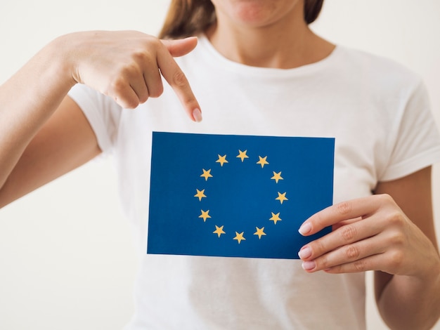 Mulher apontando para cartão com bandeira da União Europeia
