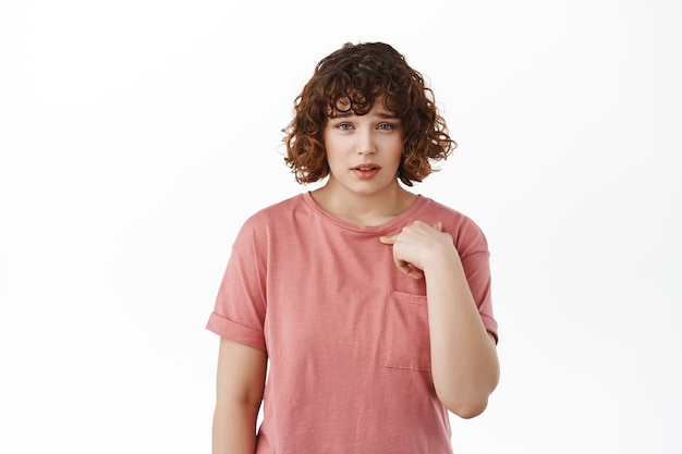 mulher apontando para si mesma com descrença, sendo escolhida ou acusada, mostrando hesitação, pisando em branco