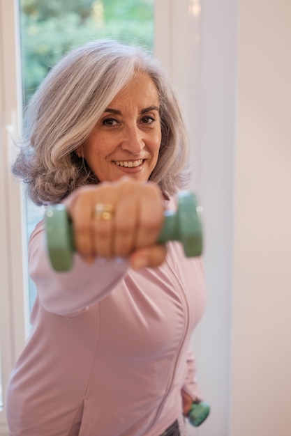 Mulher aposentada fazendo exercícios em casa para manter o corpo saudável Conceito cuidados com o corpo vida saudável rotina de exercícios