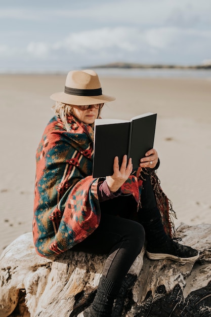 Mulher aposentada lendo um livro ao ar livre