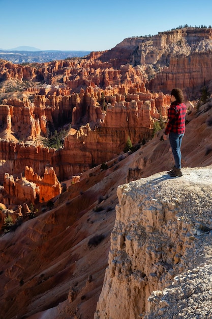 Mulher apreciando a vista de uma paisagem americana durante um dia ensolarado