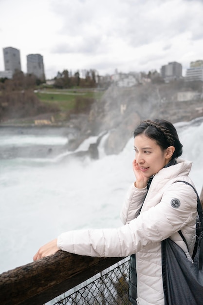 Mulher apreciando a vista do Reno cai durante o inverno na Suíça