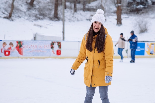 Mulher aprende a esquiar na pista de gelo da cidade