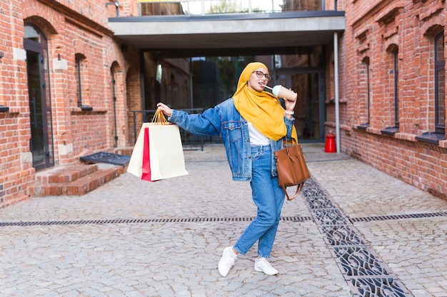 Mulher árabe bonita com sacolas de compras depois do shopping