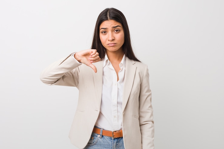 Foto mulher árabe do negócio novo isolada contra uma parede branca que mostra um gesto do desagrado, polegares para baixo. conceito de desacordo.