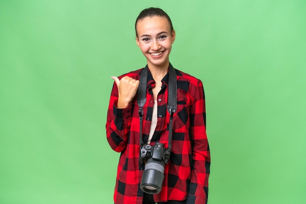 Mulher árabe jovem fotógrafo sobre fundo isolado, apontando para o lado para apresentar um produto