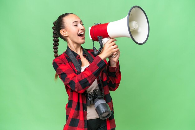 Mulher árabe jovem fotógrafo sobre fundo isolado gritando através de um megafone