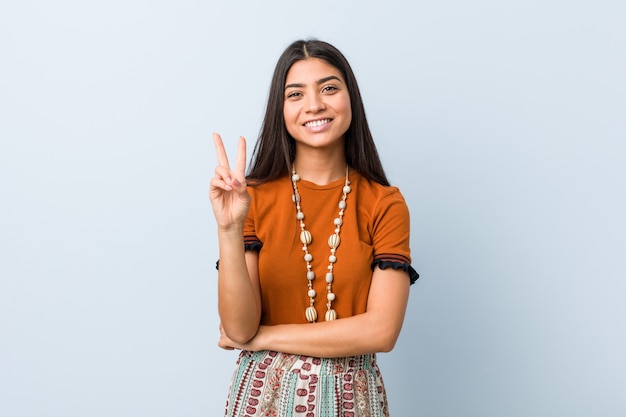 Mulher árabe nova que mostra o número dois com dedos.