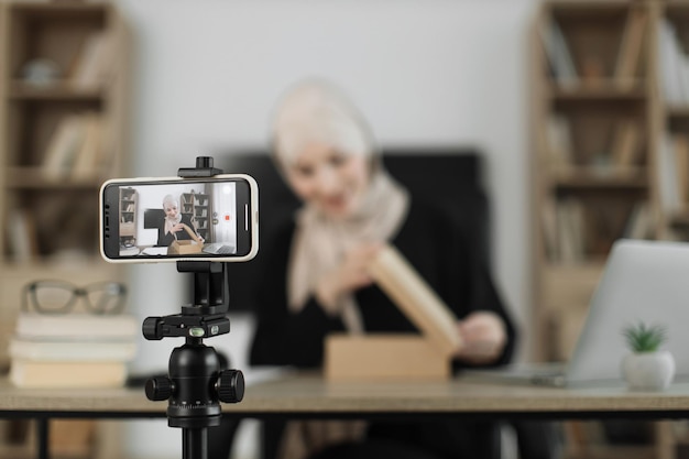 Mulher árabe usando a câmera do smartphone para criar conteúdo