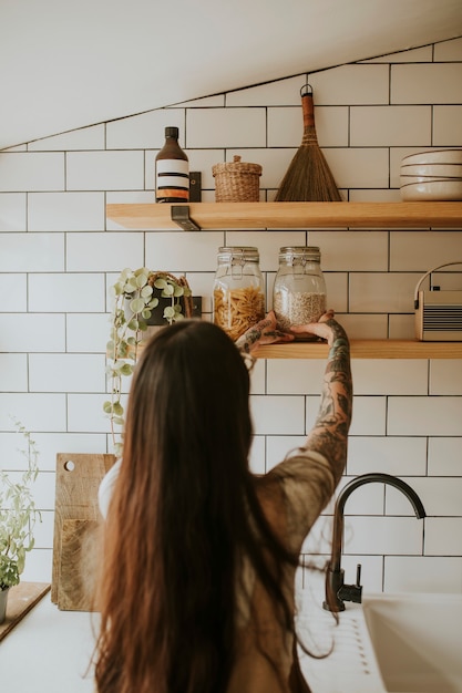 Mulher arrumando a despensa da parede da cozinha