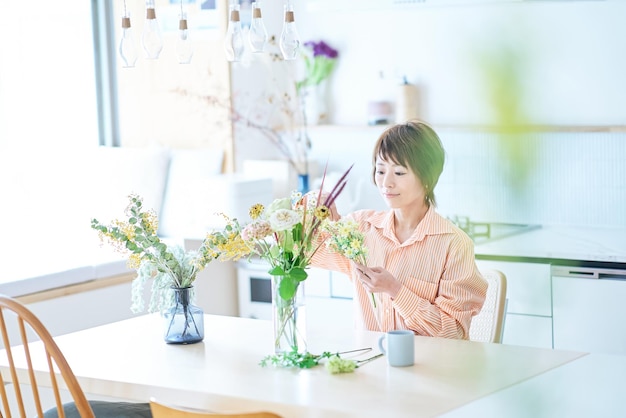 Mulher arrumando flores com vaso de flores