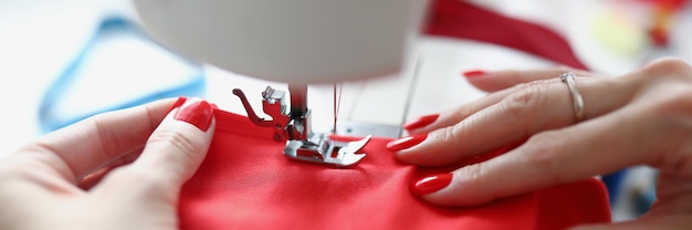 Mulher artesã em uma loja independente que conserta clientes alfaiate de roupas trabalha com pano vermelho