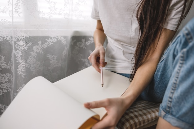 Mulher artista desenha em um caderno em casa