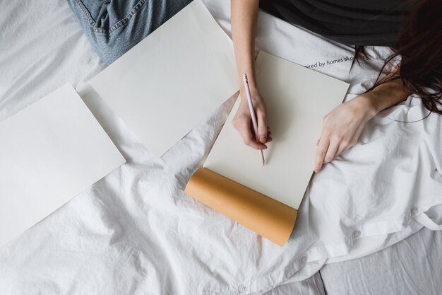 Mulher artista desenha em um caderno em casa