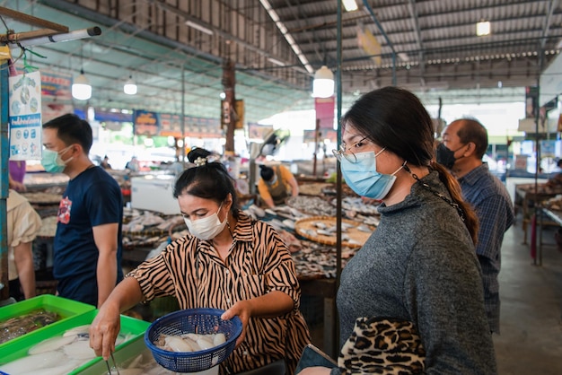 Mulher às compras no mercado de comida de rua tailandesa