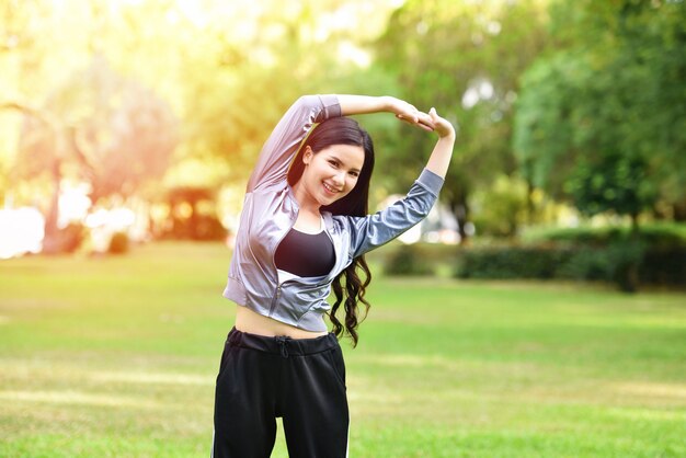 Mulher ásia manter o exercício do corpo em forma esticar os músculos para a saúde no jardim