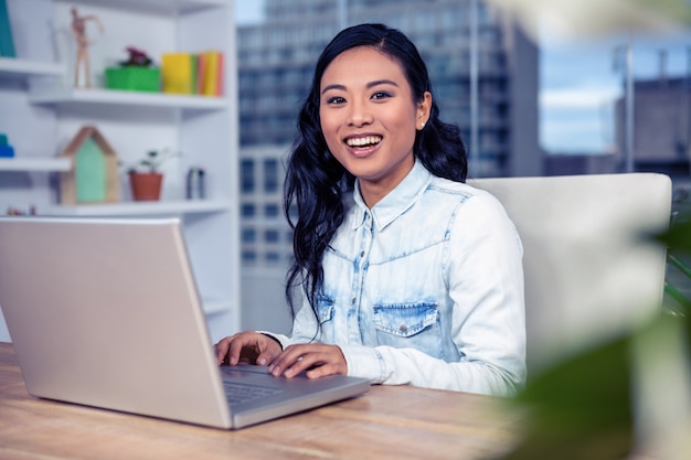 Mulher asian, usando computador portátil, em, escritório