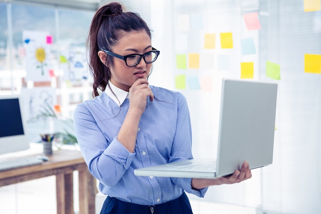 Mulher asian, usando computador portátil, em, escritório