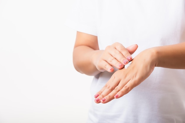 Mulher asiática aplicando creme hidratante cosmético de loção nela atrás da mão da pele da palma