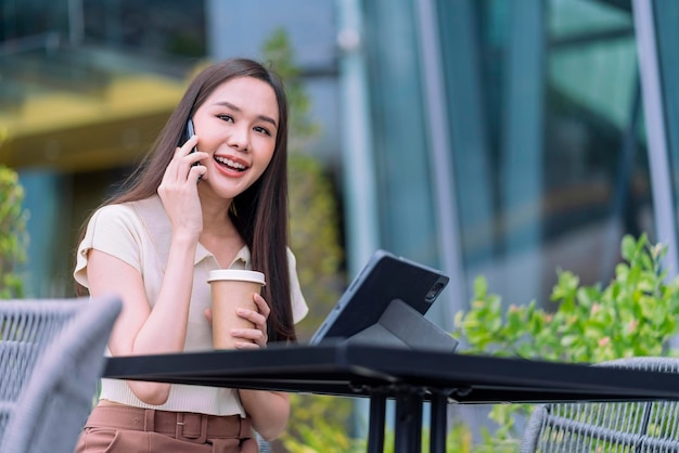 Mulher asiática atraente inteligente, pano casual, trabalho freelance, lazer, relaxe trabalhando com laptop e smartphone no café, restaurante, estilo de vida urbano, nômade digital, trabalhando no espaço de trabalho conjunto