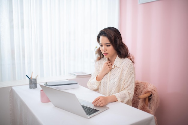 Mulher asiática bonita doente, sentindo dor no peito enquanto trabalhava com um laptop