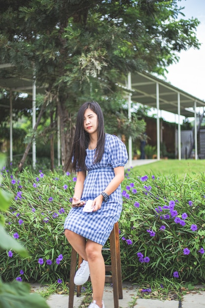 Mulher asiática bonita e sorridente fotografando plantas