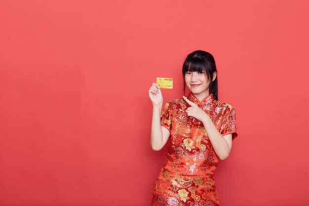 Mulher asiática bonita em um vestido tradicional com um cartão