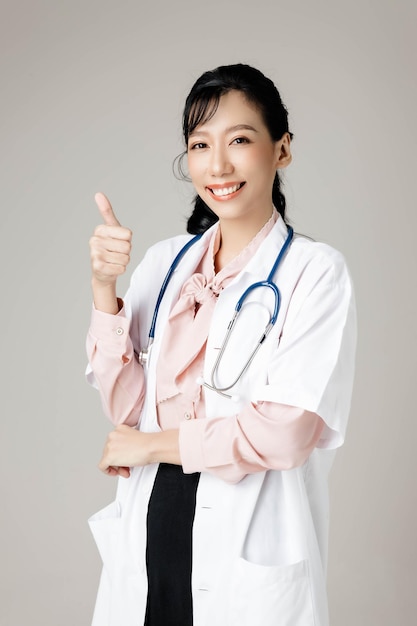 Mulher asiática bonita trabalhando feliz com roupa de escritório, sorrindo e no fundo cinza isolado