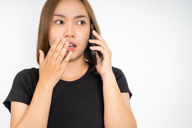 Mulher asiática chocada fazendo uma ligação usando um telefone celular