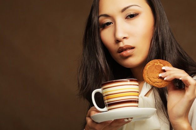 mulher asiática com café e biscoitos.