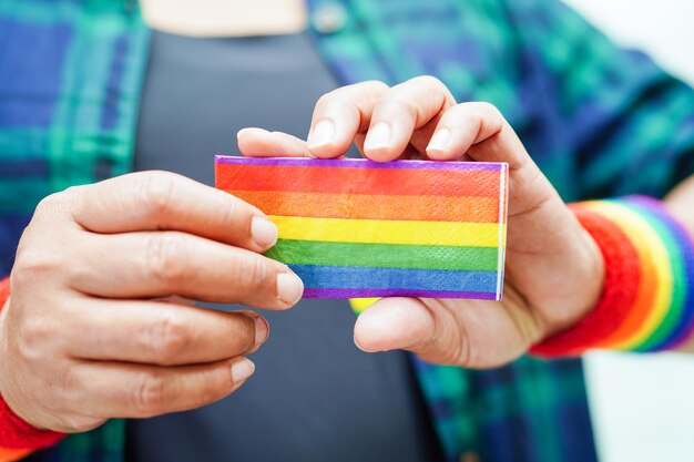 Mulher asiática com direitos do símbolo LGBT da bandeira do arco-íris e igualdade de gênero no mês do orgulho LGBT em junho