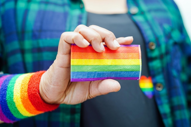 Mulher asiática com direitos do símbolo LGBT da bandeira do arco-íris e igualdade de gênero no mês do orgulho LGBT em junho