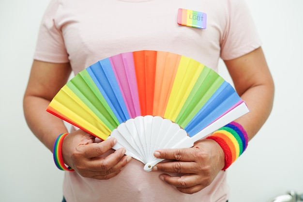 Mulher asiática com direitos do símbolo LGBT da bandeira do arco-íris e igualdade de gênero no mês do orgulho LGBT em junho