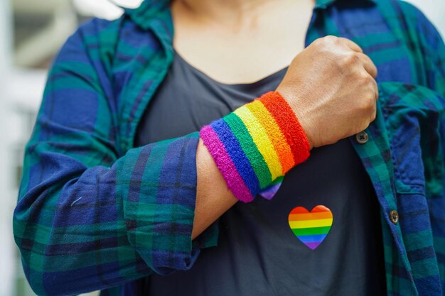 Mulher asiática com direitos do símbolo LGBT da bandeira do arco-íris e igualdade de gênero no mês do orgulho LGBT em junho