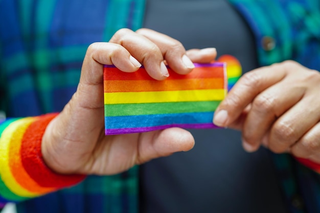 Mulher asiática com direitos do símbolo LGBT da bandeira do arco-íris e igualdade de gênero no mês do orgulho LGBT em junho