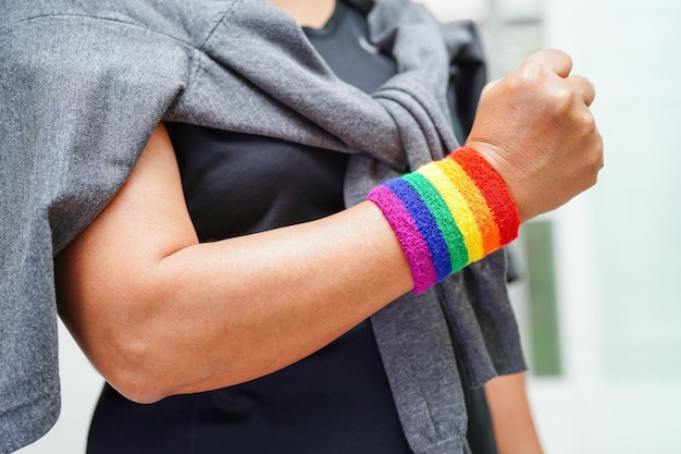 Mulher asiática com direitos do símbolo LGBT da bandeira do arco-íris e igualdade de gênero no mês do orgulho LGBT em junho