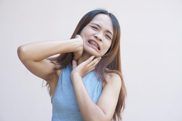 Mulher asiática com dor no pescoço