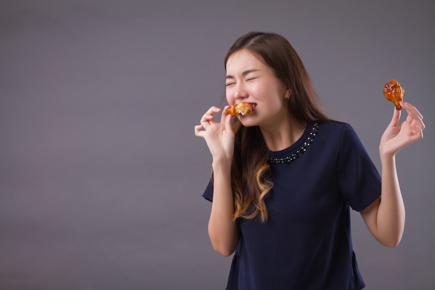 Mulher asiática com fome comendo frango frito