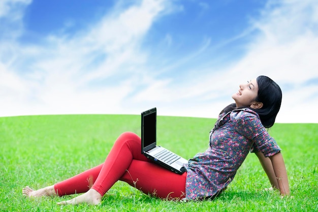 Mulher asiática com laptop ao ar livre