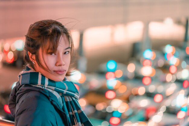 Mulher asiática com luzes da cidade no inverno