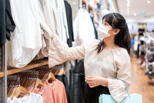 Mulher asiática com máscara protetora no shopping