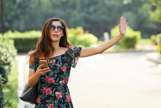 Mulher asiática com smartphone chamando táxi