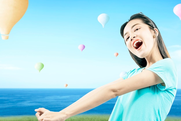 Mulher asiática com um balão de ar colorido voando com o fundo do céu azul