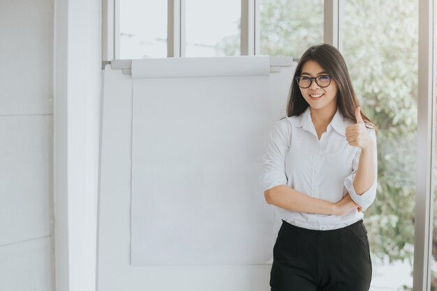 Mulher asiática confiante com flipchart em branco