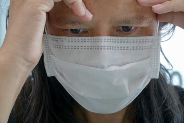 Mulher asiática de meia idade Use uma máscara para prevenir germes.
