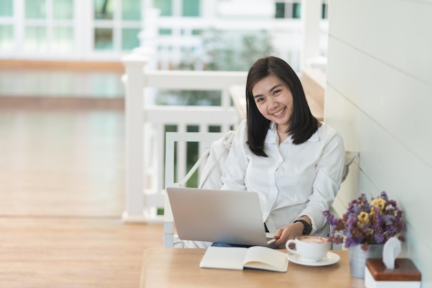 mulher asiática de negócios sorri e trabalha online com laptop e celebra o sucesso do trabalho alegre