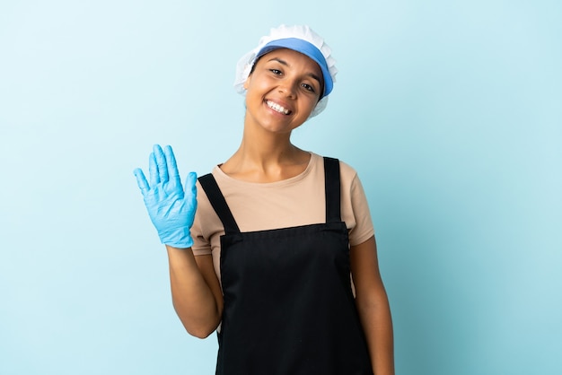 Mulher asiática de pescadora sobre fundo isolado saudando com a mão com expressão feliz