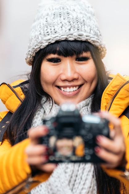 Mulher asiática de turista usando a câmera em uma rua europeia. Conceito de turismo.